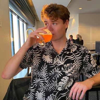 Profile image of Hans Askov drinking from a glass looking to the left out of a window.